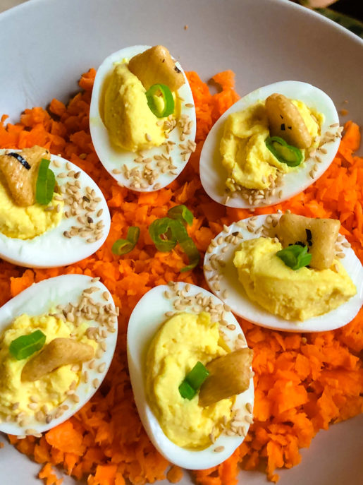main qui tient une assiette d'oeufs farcis